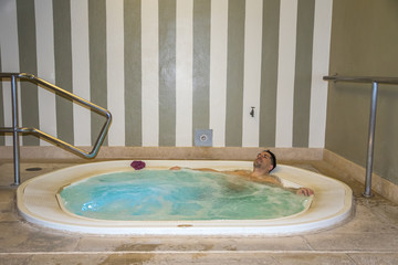 Mann allein in Whirlpool genießt warmes Bad