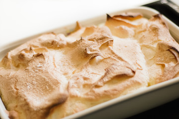 Close up of traditional, golden baked Austrian Soufflé dumpling dish, called Salzburger Nockerl, made of eggs, flour, sugar and vanilla, served warm and dusted with powdered sugar