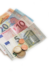 Euro banknote and coins on white background. Euro money in selective focus