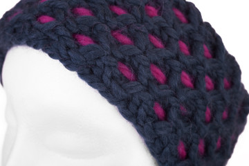 Modern handmade woollen knitted headband on a white Doll head 