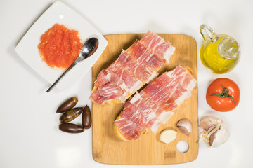 Typical Spanish breakfast consisting of Iberian acorn-fed ham with grated tomato, artisan toast, natural garlic and extra virgin olive oil