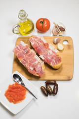 Typical Spanish breakfast consisting of Iberian acorn-fed ham with grated tomato, artisan toast, natural garlic and extra virgin olive oil