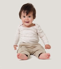 Fototapeta premium Funny baby sitting on the floor, isolated over white