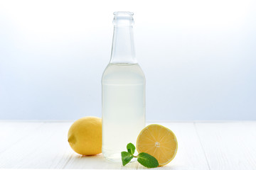 Citrus lemonade water with lemon sliced , healthy and detox water drink in summer on white wooden table with apple, oranges and lemons.