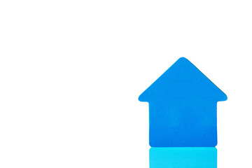 Stylized house made of blue paper on a white reflective background