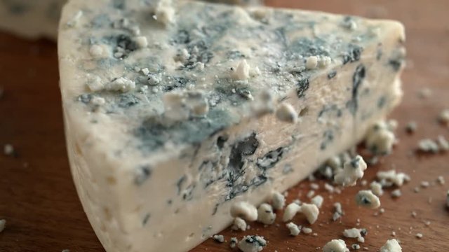 Gorgonzola cheese on wooden board. Shot with high speed camera, phantom flex 4K. Slow Motion.
