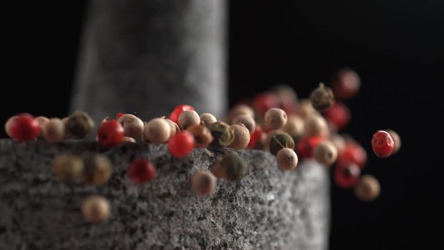 Grinding peppercorn with mortar and pestle. Shot with high speed camera, phantom flex 4K. Slow Motion.