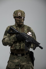 Photo of military man in camouflage with gun