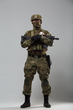 Image of soldier in camouflage with gun in studio