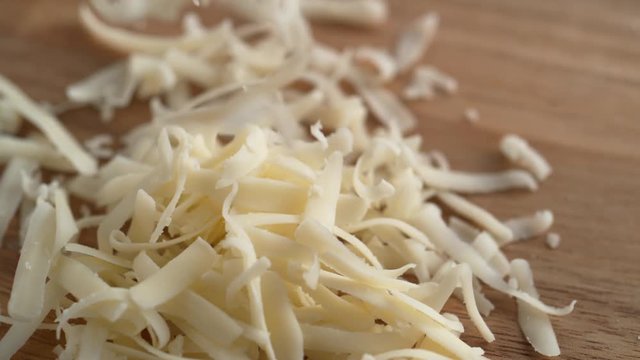 Grating white cheddar cheese. Shot with high speed camera, phantom flex 4K. Slow Motion.