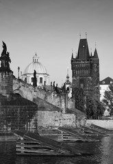 Fototapeta na wymiar Black-and-white photograph of the Charles bridge with retouch antique. Attraction in the historical centre of Prague, photo from the river