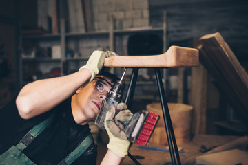 Naklejka premium Young master carpenter working in his woodwork or workshop.
