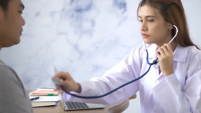 Female Doctor used stethoscope with young patient man in hospital