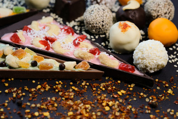 Appetizing truffles and pieces of sweet pizza on a black background