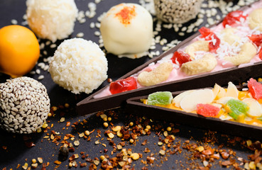 Appetizing truffles and pieces of sweet pizza on a black background
