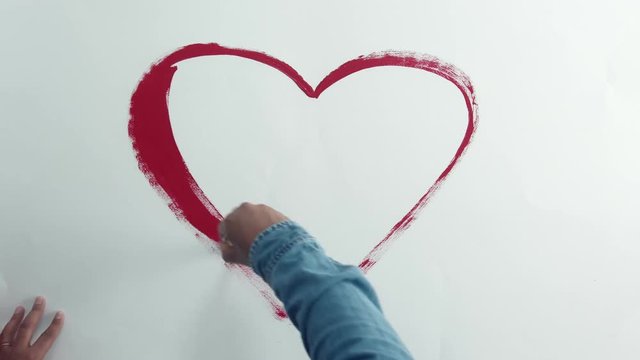 man drawing red heart top view