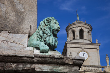 Fototapeta na wymiar Francia, Arles. Il campanile del municipio e statua di leone sulla fontana della piazza centrale.