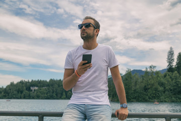 Modern guy using cellphone in nature.