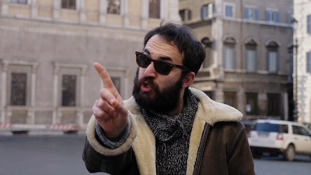 angry handsome man  making "No" with finger at camera  in the street