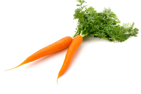 Carrot vegetable with leaves on the wooden background.