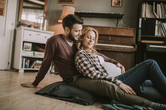 Pregnant woman with a husband sitting on the floor