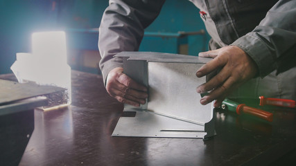Worker assembling the metal part in the manual