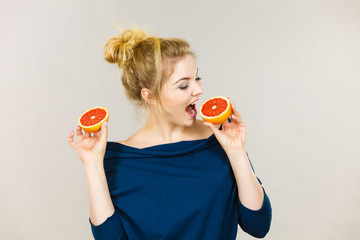 Happy smiling woman holding red grapefruit