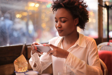 Girl taking a photo of her food in a restaurant