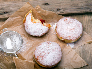 Traditional Polish donuts on wooden background. Tasty doughnuts with jam.