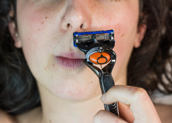 girl removing her mustache with a razor