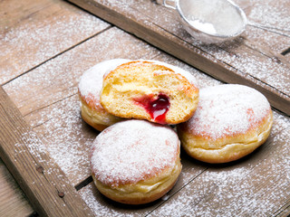 Traditional Polish donuts on wooden background. Tasty doughnuts with jam.