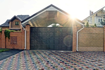 Large closed brown gates and part of the fence