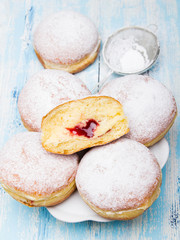 Traditional Polish donuts on wooden background.  Tasty doughnuts with jam.