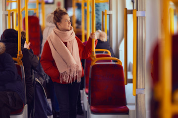 Young pretty girl stand in the tramway and look at window - obrazy, fototapety, plakaty