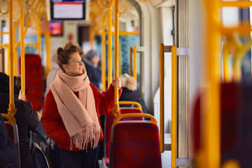 Young pretty girl stand in the tramway and look at window - obrazy, fototapety, plakaty