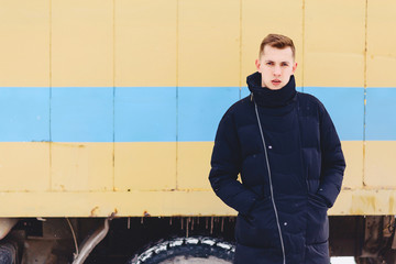 boy in a winter jacket against the background of the wall