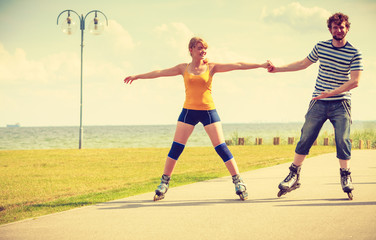 Young couple on roller skates riding outdoors