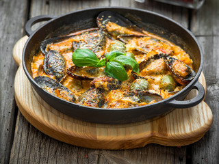 mussels with cheese sauce, in a frying pan