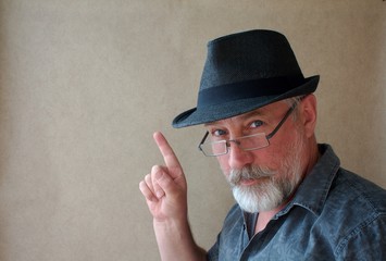 a middle aged man with beard and mustache in black hat noted something