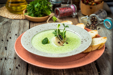 Spinach cream soup in bowl on white rustic table, top view
