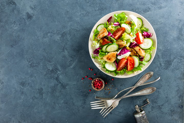 Fresh vegetable salad of tomatoes, cucumbers, italian mix, lettuce and grilled chicken breast. Fried chicken meat, fillet with salad. Healthy food. Flat lay. Top view