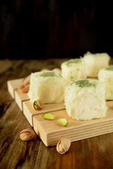 Turkish dessert. Cotton candy with pistachio on wooden boards surrounded by nuts
