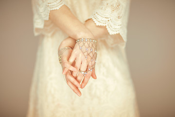 beautiful woman figure in vintage boho wedding dress showing her hands with vintage hand jewelry