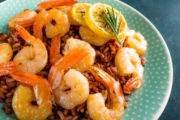 Prawns roasted on grill and boiled brown rice on plate. Grilled shrimps, prawns with rice. Seafood. Asian cuisine. Closeup. Dark background