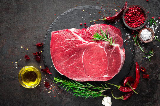 Raw beef steak on black background with cooking ingredients. Fresh beef meat. Top view