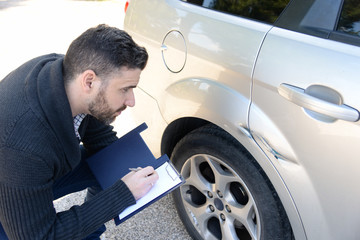 insurance agent assessing the damages of a vehicle