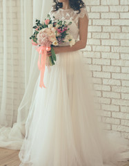 Fototapeta na wymiar bride from a wedding bouquet near a white wall