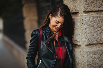 Portrait of a happy young woman in a leather jacket outdoor