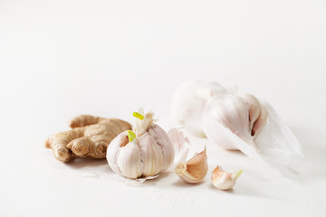 Garlic heads and ginger root on white background
