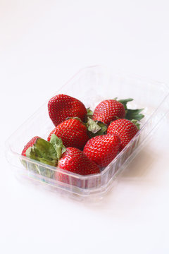 Fresh Strawberries in a little transparent box, on white background.